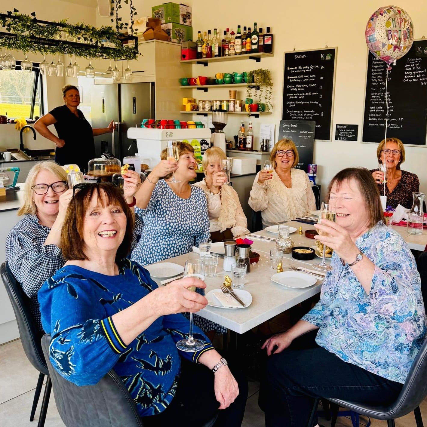 Guests celebrating around a table at Knowle Grange Cafe
